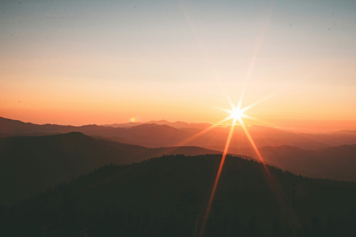 Atardecer de verano sobre una cordillera en tonos cálidos