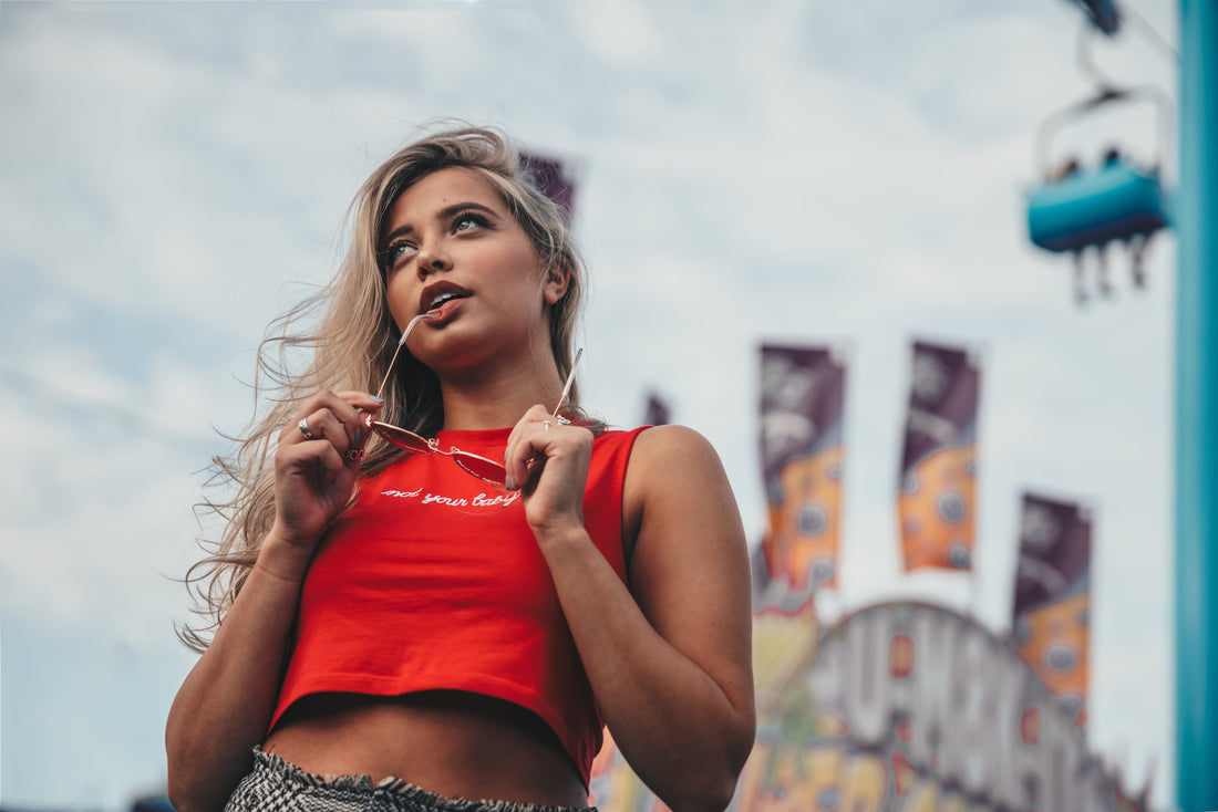 Mujer sostiene unas gafas de sol entre las manos en un entorno urbano